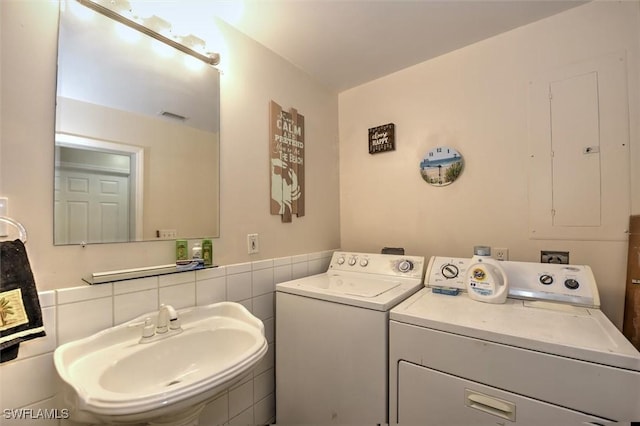 clothes washing area with a sink, separate washer and dryer, laundry area, and visible vents