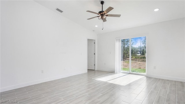 spare room with visible vents, baseboards, ceiling fan, and vaulted ceiling