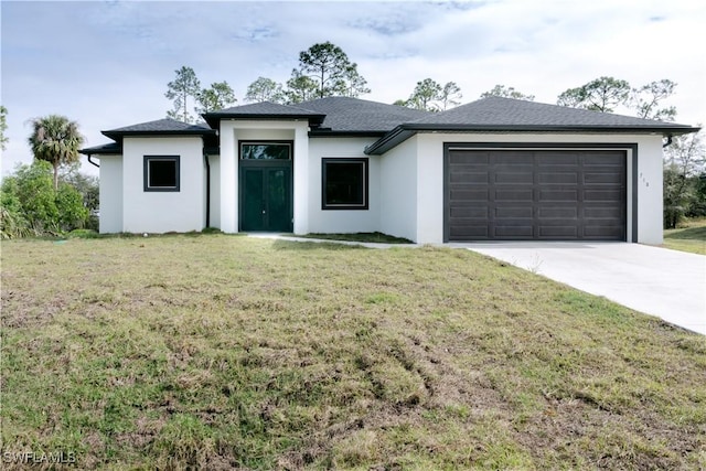 prairie-style home featuring an attached garage, concrete driveway, stucco siding, and a front yard