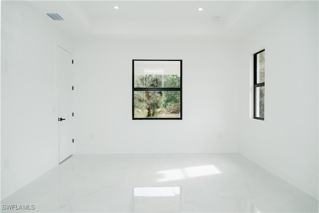 unfurnished room with visible vents, recessed lighting, and a raised ceiling