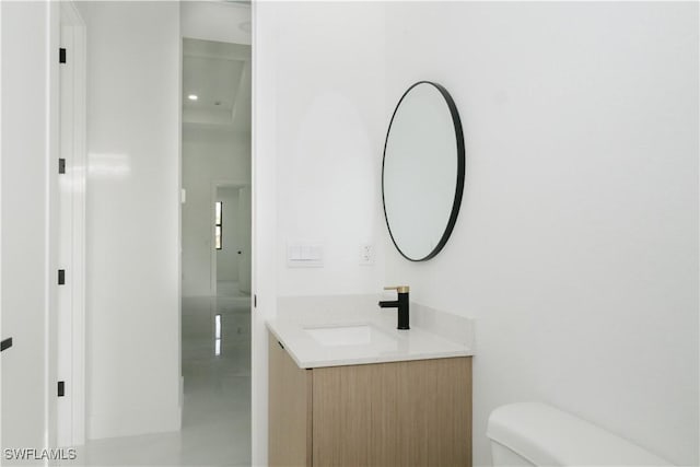 half bathroom featuring vanity and toilet
