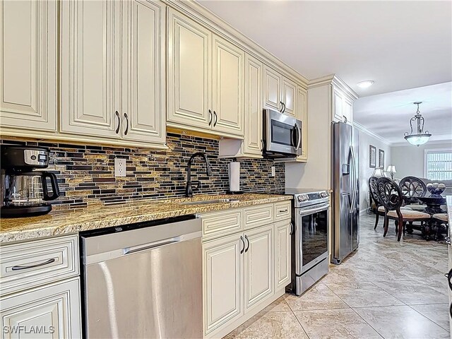 4211 SE 19th Pl Unit 1C, Cape Coral, FL 33904 - kitchen featuring appliances with stainless steel finishes, a sink, cream cabinetry, tasteful backsplash, and crown molding