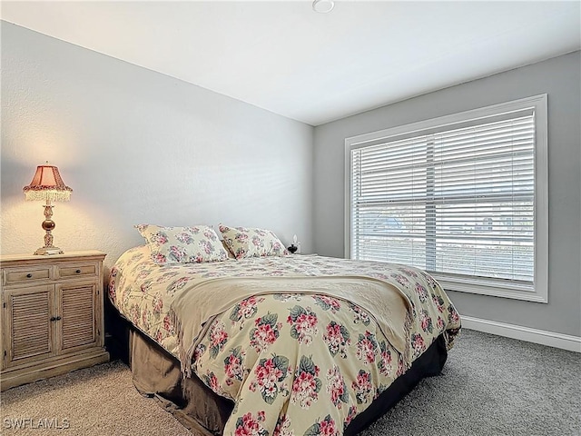 bedroom with light colored carpet and baseboards