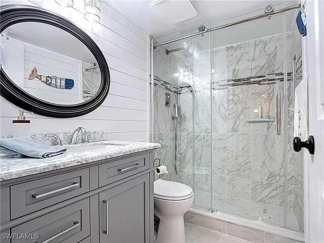 4211 SE 19th Pl Unit 1C, Cape Coral, FL 33904 - bathroom featuring toilet, a shower stall, vanity, tile patterned floors, and wood walls