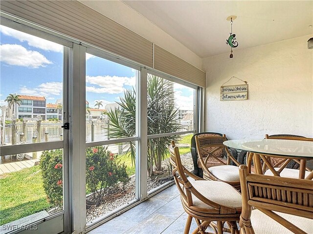 4211 SE 19th Pl Unit 1C, Cape Coral, FL 33904 - sunroom / solarium featuring a textured wall, a water view, and tile patterned floors
