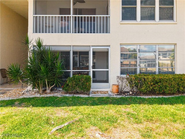 4211 SE 19th Pl Unit 1C, Cape Coral, FL 33904 - view of exterior entry featuring stucco siding, a lawn, and a carport