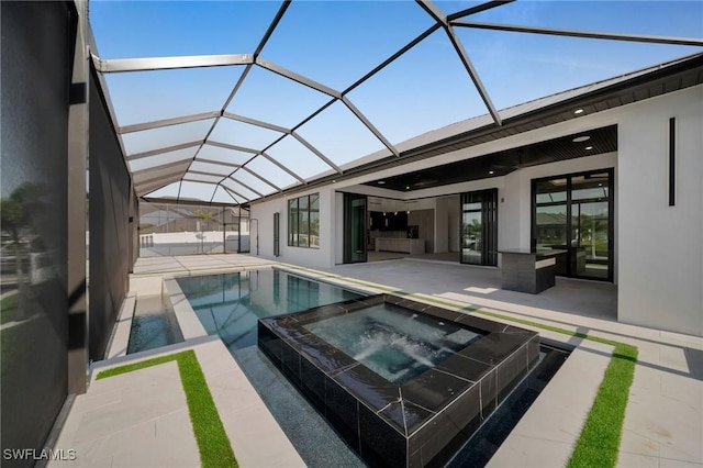 view of swimming pool with glass enclosure, a patio, a pool with connected hot tub, and ceiling fan
