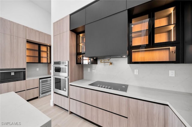 kitchen with light countertops, black electric cooktop, decorative backsplash, and wine cooler
