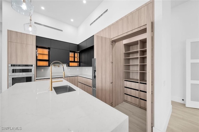 3617 Embers Pkwy W, Cape Coral, FL 33993 - kitchen with modern cabinets, light wood-type flooring, open shelves, double oven, and recessed lighting