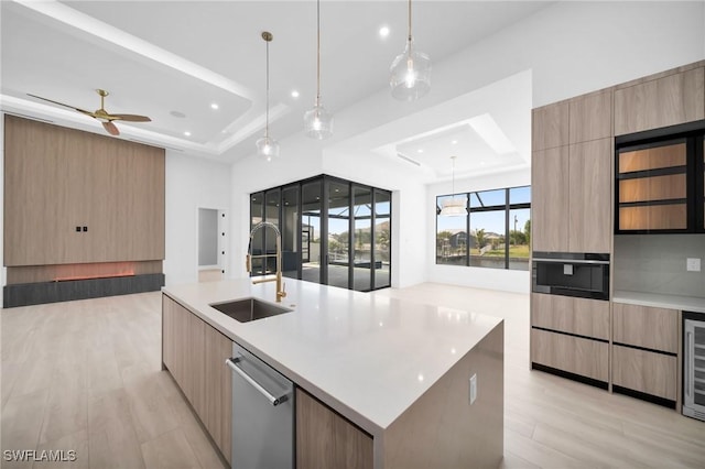 kitchen featuring a sink, modern cabinets, a tray ceiling, and recessed lighting