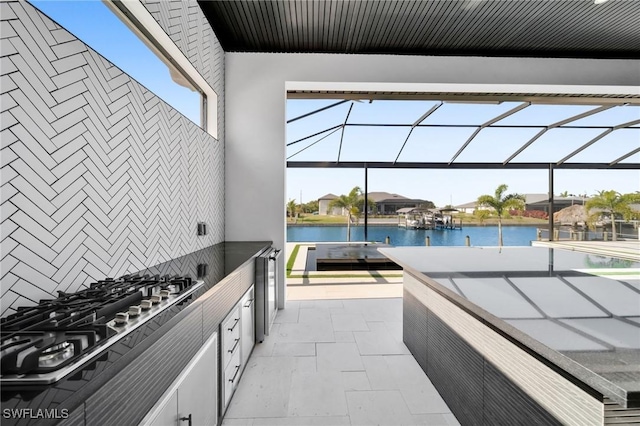 view of patio / terrace with a water view and a lanai