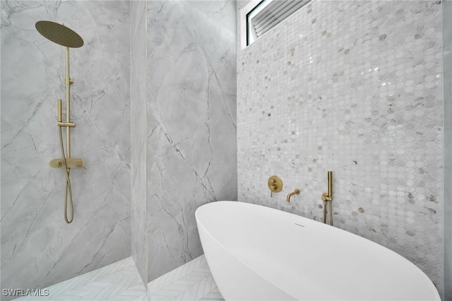 full bathroom with a freestanding tub, a marble finish shower, and tile walls