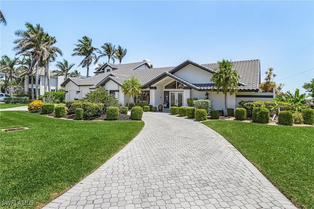view of front of home featuring french doors, a front yard, and stucco siding