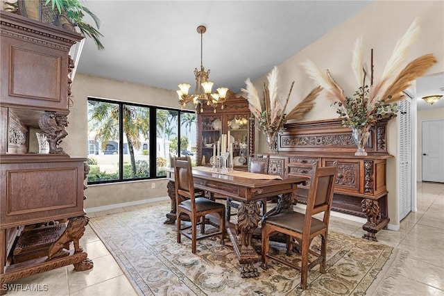 dining area featuring a chandelier, light tile patterned flooring, and baseboards