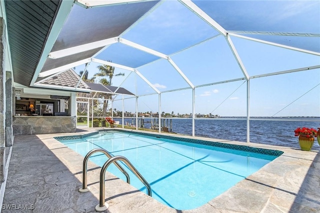 swimming pool with a water view, a patio area, and a lanai