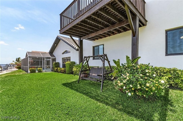 back of property with stucco siding and a lawn