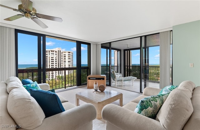 carpeted living area featuring a ceiling fan and floor to ceiling windows
