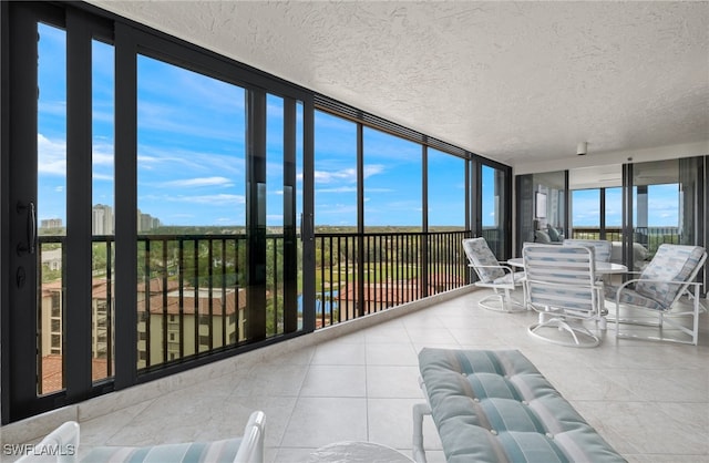 sunroom with tile patterned flooring and a textured ceiling