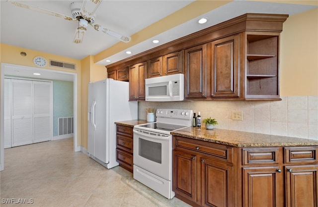 kitchen with light stone counters, a ceiling fan, white appliances, and visible vents