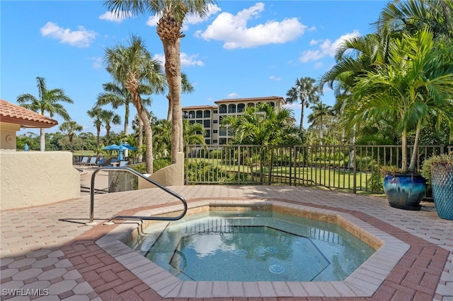 view of pool featuring fence and a hot tub
