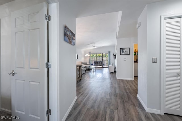corridor with baseboards and wood finished floors
