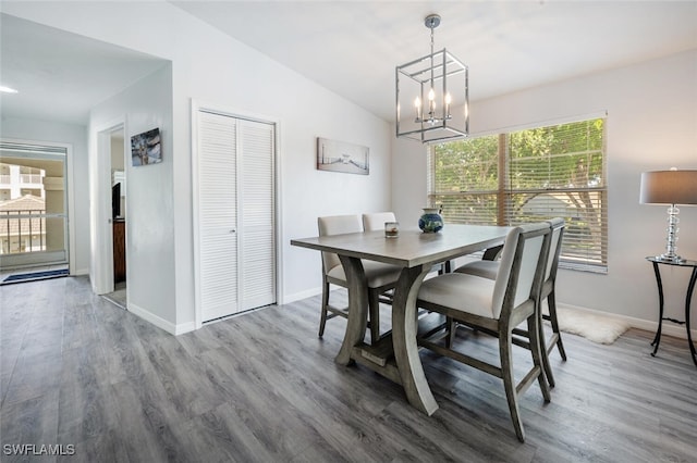 dining room with baseboards, an inviting chandelier, and wood finished floors