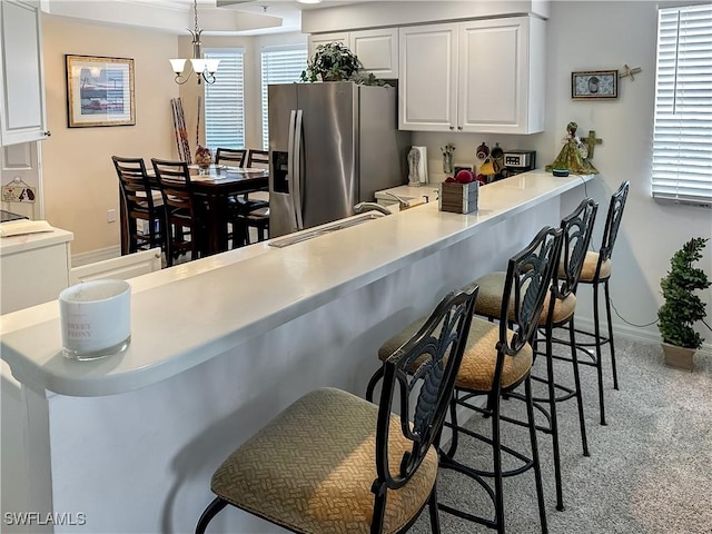 1787 Four Mile Cove Pkwy Unit 431, Cape Coral, FL 33990 - kitchen featuring a sink, a kitchen bar, stainless steel refrigerator with ice dispenser, light carpet, and white cabinets