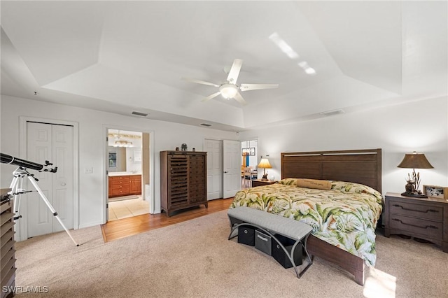 326 Mcarthur Ave, Lehigh Acres, FL 33936 - bedroom with a tray ceiling, light carpet, ceiling fan, and ensuite bath