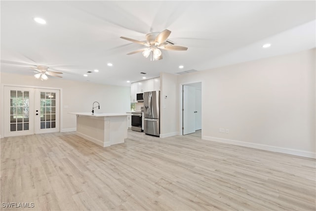 kitchen featuring open floor plan, a sink, ceiling fan, and stainless steel appliances