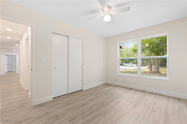unfurnished bedroom with light wood-style floors, recessed lighting, baseboards, a ceiling fan, and a closet