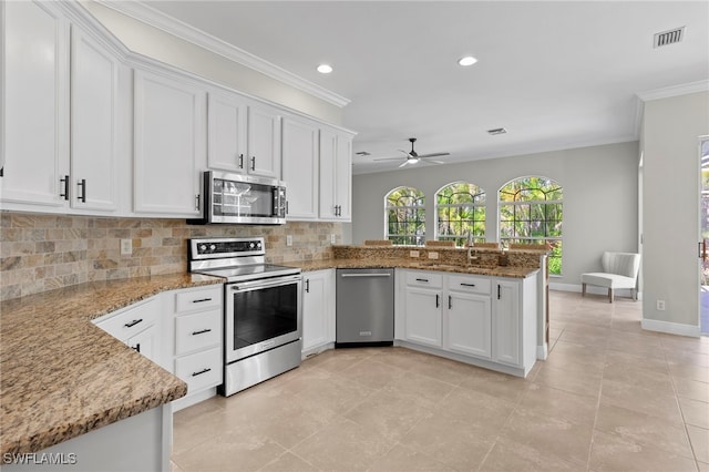kitchen featuring recessed lighting, a peninsula, appliances with stainless steel finishes, and backsplash