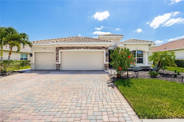 2094 Satsuma Ln, Naples, FL 34120 - view of front of home with decorative driveway, a tile roof, a garage, stucco siding, and stone siding