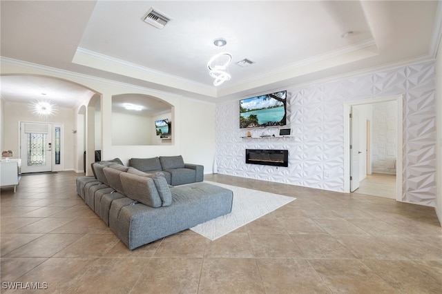 2094 Satsuma Ln, Naples, FL 34120 - living area featuring arched walkways, ornamental molding, a tray ceiling, a glass covered fireplace, and light tile patterned floors