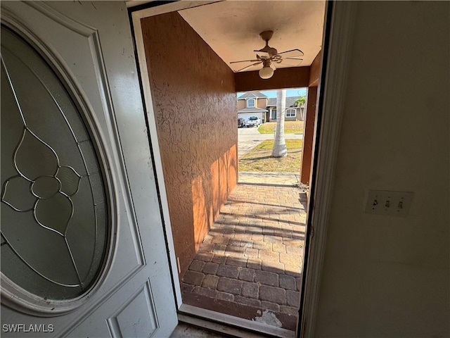 view of exterior entry with a ceiling fan