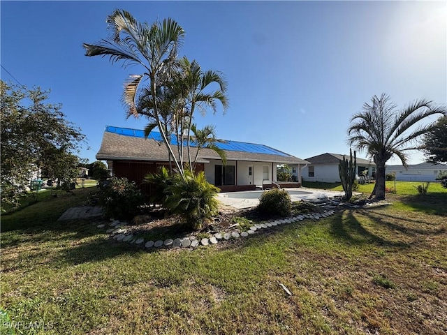 view of front of home with a patio and a front lawn