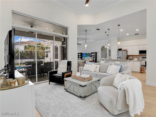 living area featuring crown molding, recessed lighting, light wood finished floors, and a sunroom