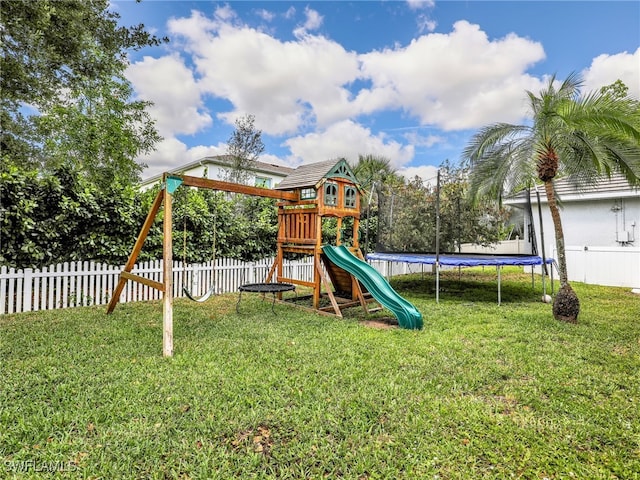 view of play area featuring a yard, fence, and a trampoline