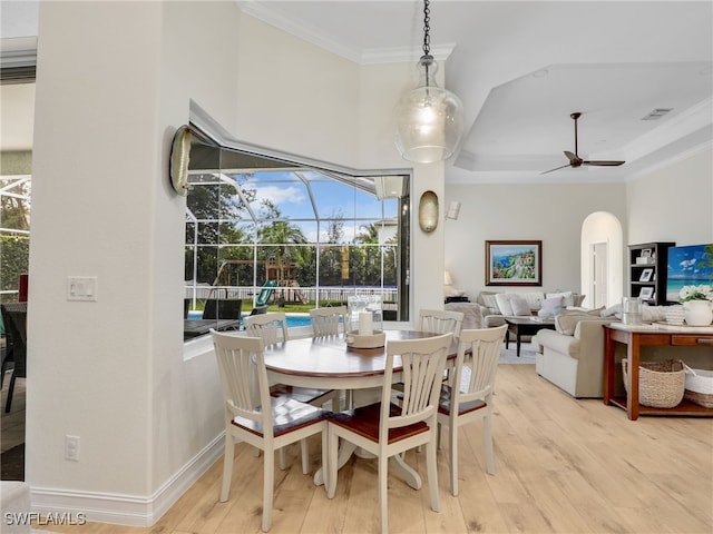 dining area featuring a sunroom, plenty of natural light, ornamental molding, and light wood-style floors