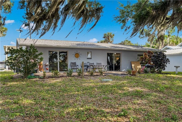 rear view of house with a lawn and a patio