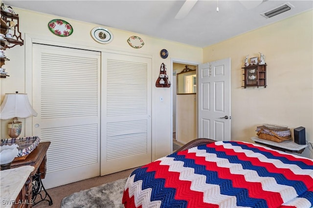 bedroom featuring carpet floors, ceiling fan, visible vents, and a closet