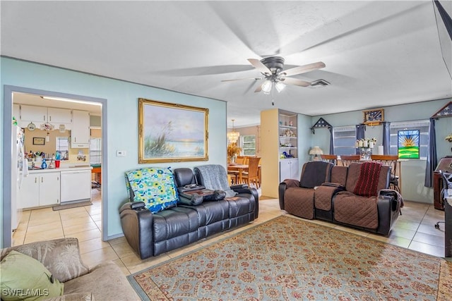 living area with ceiling fan, visible vents, and light tile patterned floors