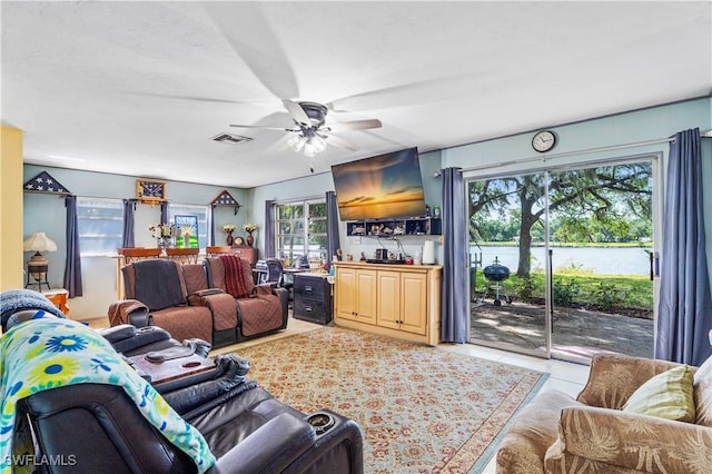 living room featuring light tile patterned floors, ceiling fan, and visible vents