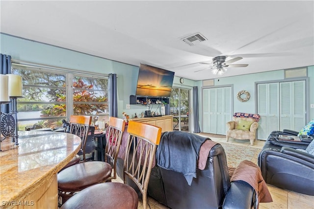 living room featuring a ceiling fan and visible vents