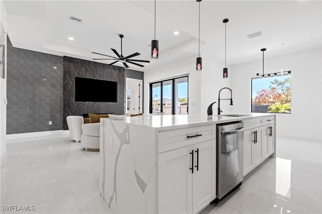 kitchen featuring ceiling fan, visible vents, stainless steel dishwasher, a sink, and an accent wall