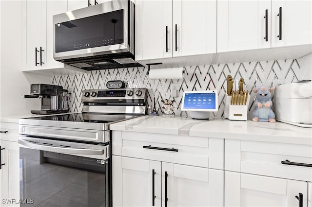 kitchen with stainless steel appliances, white cabinetry, and tasteful backsplash