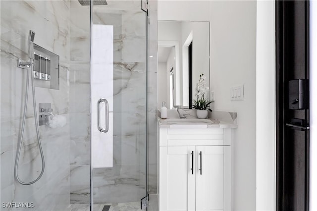 bathroom with a marble finish shower and vanity