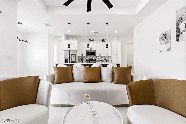 living room with visible vents, recessed lighting, a raised ceiling, and ceiling fan