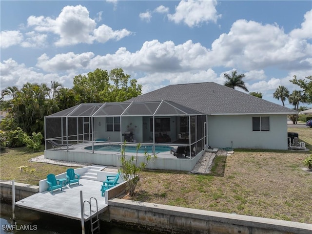 back of property with a patio area, roof with shingles, an outdoor pool, and a lawn