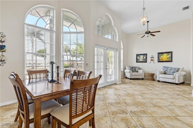 dining space featuring high vaulted ceiling, plenty of natural light, ceiling fan, and visible vents