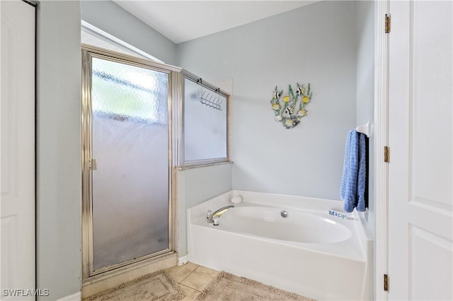 full bathroom featuring tile patterned floors, a shower stall, and a bath